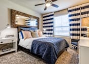 Thumbnail 7 of 16 - Beautifully designed guest bedroom at 33hundred Apartments in Austin TX with large windows and modern décor.