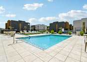 Thumbnail 34 of 45 - A pool surrounded by a tiled patio and lounge chairs.