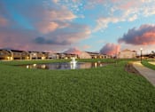 Thumbnail 37 of 47 - A row of houses with a grassy area in front and a pond in the middle.