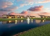 Thumbnail 39 of 47 - A serene lakeside view of a residential area with houses and a fountain.