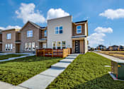 Thumbnail 23 of 47 - A modern house with a well-maintained lawn and a clear sky.