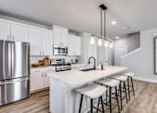 Thumbnail 7 of 47 - A modern kitchen with a white island and stainless steel appliances.