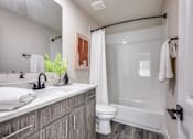 Thumbnail 19 of 47 - A bathroom with a white toilet and a white bathtub.