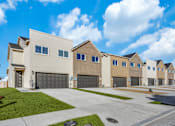 Thumbnail 24 of 47 - A row of modern houses with garages and driveways.