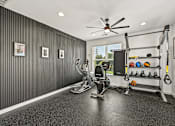 Thumbnail 40 of 48 - A home gym with a variety of equipment including a treadmill, weights, and a pull-up bar.