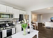 Thumbnail 4 of 15 - Modern kitchen with stainless steel appliances and white cabinetry at Ashford at Geneva Apartments in Geneva, IL – pet-friendly homes in the Far Northwest Chicago Suburbs