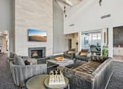 Thumbnail 45 of 46 - A living room with a fireplace and a painting of a desert landscape on the wall.