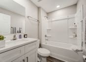 Thumbnail 29 of 29 - Pet-Friendly Rentals in Lady Lake, FL – The Groves at Lake Ella - white bathroom with a tub and a sink and a toilet