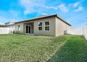 Thumbnail 63 of 63 - A house with a white fence and a green lawn.