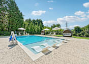 Thumbnail 2 of 48 - A large resort-style swimming pool at Hawks Landing in Hickory NC surrounded by trees and lounge chairs