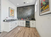Thumbnail 40 of 46 - A kitchen with white cabinets and a wooden floor.