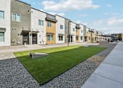 Thumbnail 16 of 20 - A row of modern townhouses with a grassy area in the foreground.