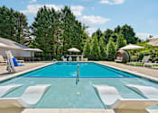 Thumbnail 29 of 48 - A large Hawks Landing swimming pool in Hickory NC with white lounge chairs and umbrellas