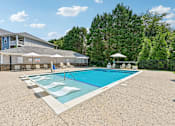 Thumbnail 28 of 48 - A bright Hawks Landing pool area in Hickory NC lined with white lounge chairs and umbrellas