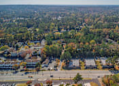 Thumbnail 19 of 25 - An aerial view of a suburban area with a road intersection and apartment buildings.