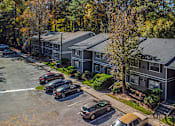 Thumbnail 24 of 25 - A parking lot with cars and apartment buildings in the background.