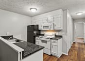 Thumbnail 1 of 25 - Element at 3900, Macon Apartments A kitchen with black appliances and white cabinets.