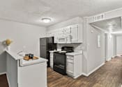 Thumbnail 4 of 25 - A kitchen with black appliances and white cabinets.