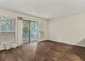 Thumbnail 15 of 25 - A room with wooden floors and a sliding glass door.