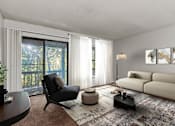 Thumbnail 8 of 25 - A modern living room with a black chair and a beige sofa.
