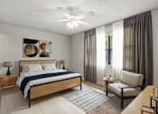 Thumbnail 10 of 25 - A bedroom with a bed, chair, and a ceiling fan.