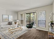 Thumbnail 6 of 25 - A living room with a white couch, a coffee table, and a chair.