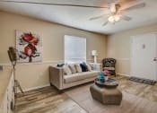 Thumbnail 4 of 15 - Derby Park Apartments in Daytona Beach, FL photo of a living room with a couch and a ceiling fan