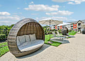 Thumbnail 30 of 48 - A white cushioned lounge pod at the Hawks Landing pool in Hickory NC providing a relaxing seating area for residents