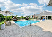 Thumbnail 27 of 48 - A pool with a sun umbrella and a bench.