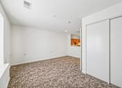 Thumbnail 4 of 32 - A room with a carpeted floor and a white door.