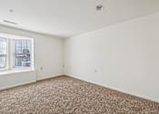 Thumbnail 3 of 32 - A room with a carpeted floor and a window.