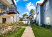 Thumbnail 17 of 20 - Pet-Friendly Apartments in Beaumont, TX – Breakwater Bay - outside pathway between community buildings