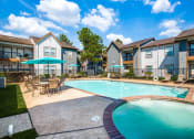 Thumbnail 5 of 20 - Pet-Friendly Apartments in Beaumont, TX – Breakwater Bay - swimming pool with umbrellas and beach chairs