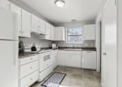 Thumbnail 4 of 23 - Element at 4411 Macon Apartments A kitchen with white appliances and cabinets.