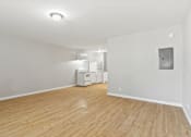 Thumbnail 13 of 23 - Element at 4411 Macon Apartments A room with wooden flooring and white walls, with a washing machine and dryer in the corner.