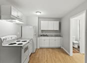 Thumbnail 1 of 23 - Element at 4411 Macon Apartments A white kitchen with a stove top oven and a refrigerator.