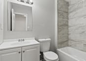 Thumbnail 15 of 23 - Element at 4411 Macon Apartments A white bathroom with a sink, toilet and tub.