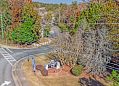 Thumbnail 19 of 23 - Element at 4411 Macon Apartments A road with a sign that says 4211 is surrounded by trees.