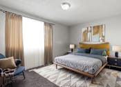 Thumbnail 10 of 23 - Element at 4411 Macon Apartments A bedroom with a bed, chair, and two lamps.