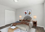 Thumbnail 12 of 23 - Element at 4411 Macon Apartments A bedroom with a bed, two lamps, and a painting on the wall.