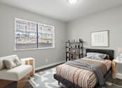 Thumbnail 9 of 23 - Element at 4411 Macon Apartments A bedroom with a bed, chair, and shelves.