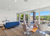 Thumbnail 23 of 32 - A living room with a blue sofa and a glass wall.