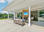 Thumbnail 31 of 48 - An outdoor lounge area at Hawks Landing in Hickory NC featuring a mounted TV and comfortable seating