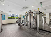 Thumbnail 18 of 31 - A gym with a variety of equipment including treadmills, weights, and exercise machines.