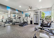 Thumbnail 21 of 32 - A spacious home gym with treadmills, elliptical machines, and other exercise equipment.