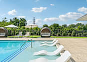 Thumbnail 26 of 48 - A refreshing swimming pool at Hawks Landing in Hickory NC surrounded by white loungers and umbrellas
