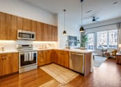 Thumbnail 2 of 28 - A modern kitchen with wooden cabinets and stainless steel appliances.