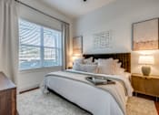 Thumbnail 5 of 28 - A bedroom with a large bed and two lamps.
