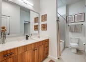 Thumbnail 6 of 28 - A bathroom with a white counter top and wooden cabinets.