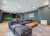 Thumbnail 14 of 28 - A living room with a grey sofa and a wooden coffee table.